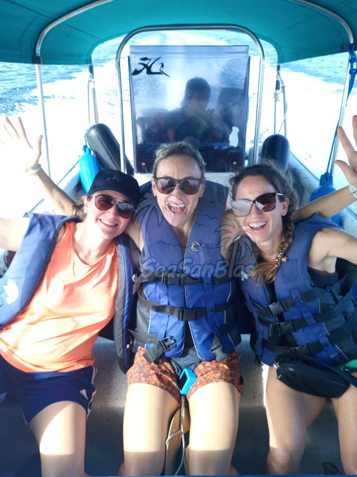 Three women wearing life vests are posing for a picture on a boat San Blas Islands Guna Yala San Blas Tours