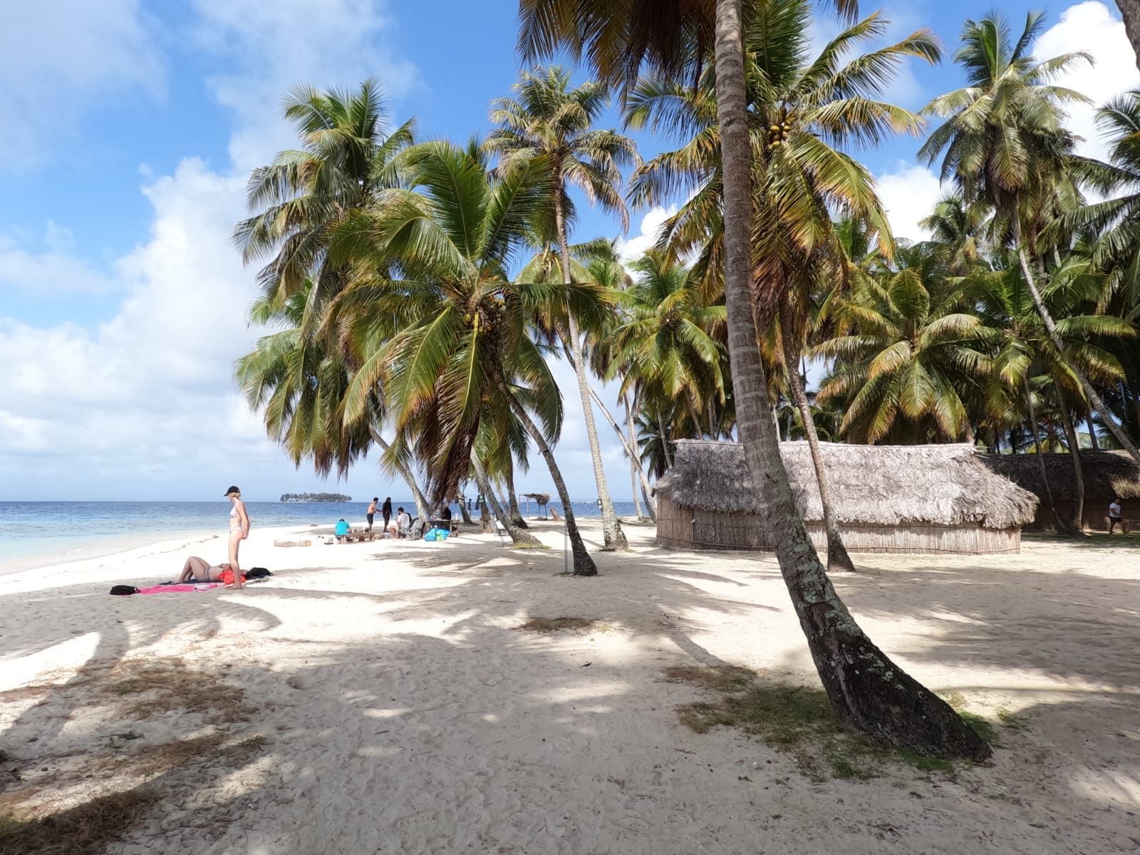 Two lounge chairs under an umbrella on a beach