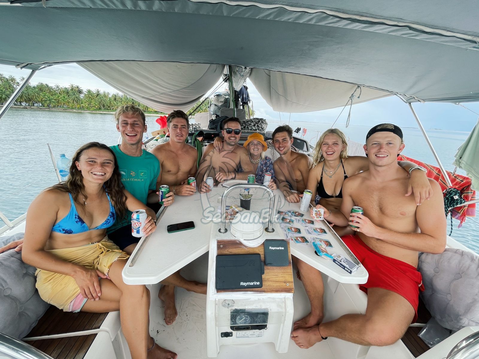 a group of people are sitting around a table on a boat