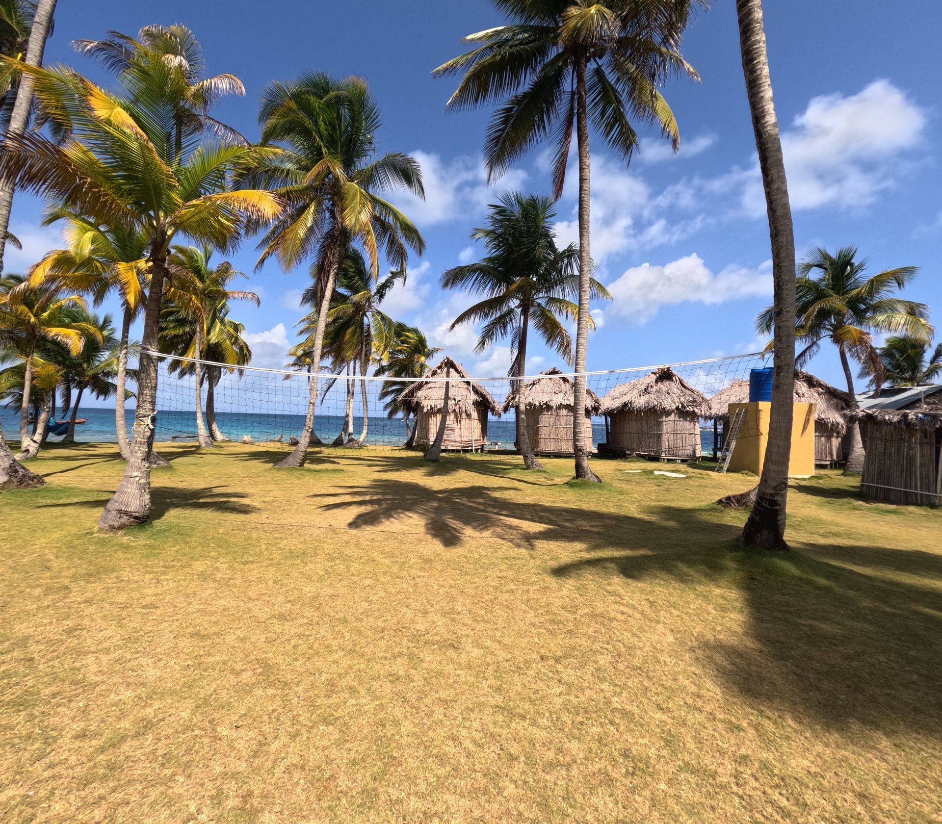 Two lounge chairs under an umbrella on a beach