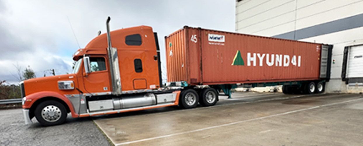 Orange semi-truck with a container labeled 
