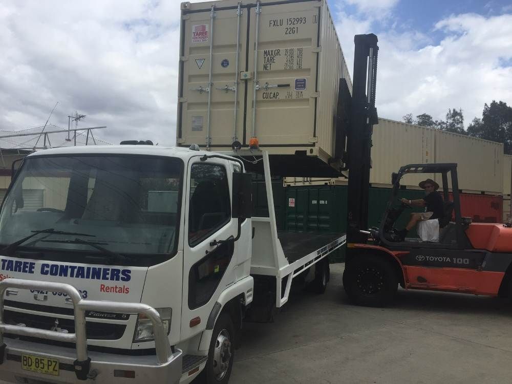 A Forklift Is Loading A Shipping Container Onto A Truck — Taree Containers in Taree, NSW