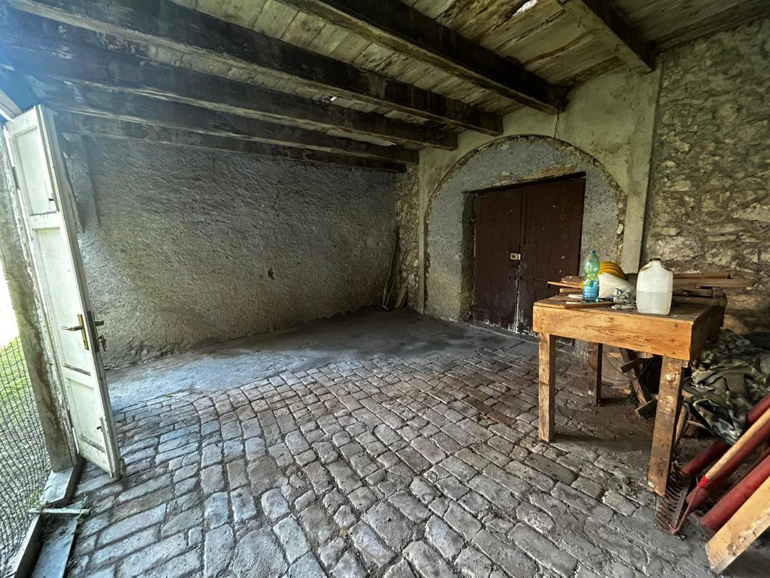 Una stanza vuota con un tavolo di legno e una porta di legno.