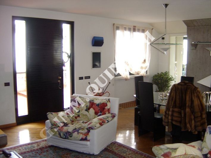 Un soggiorno con una sedia e una porta con scritto immoquin