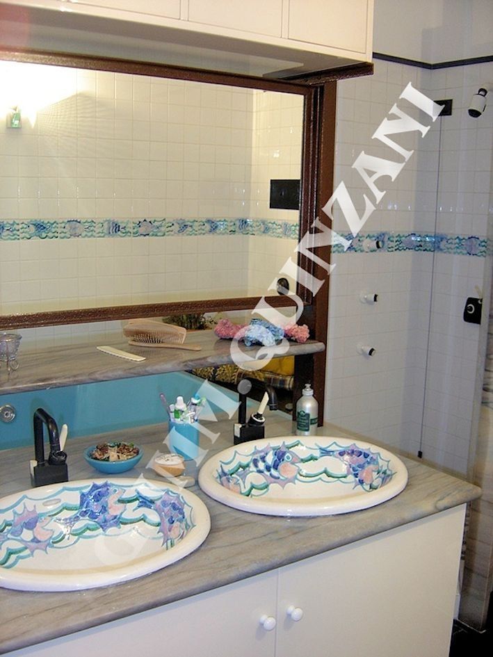 Un bagno con due lavandini e uno specchio con la scritta 