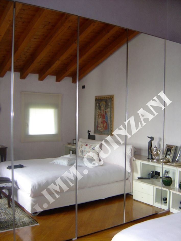 Una camera da letto con un grande specchio dietro il letto che dice immoquinzani