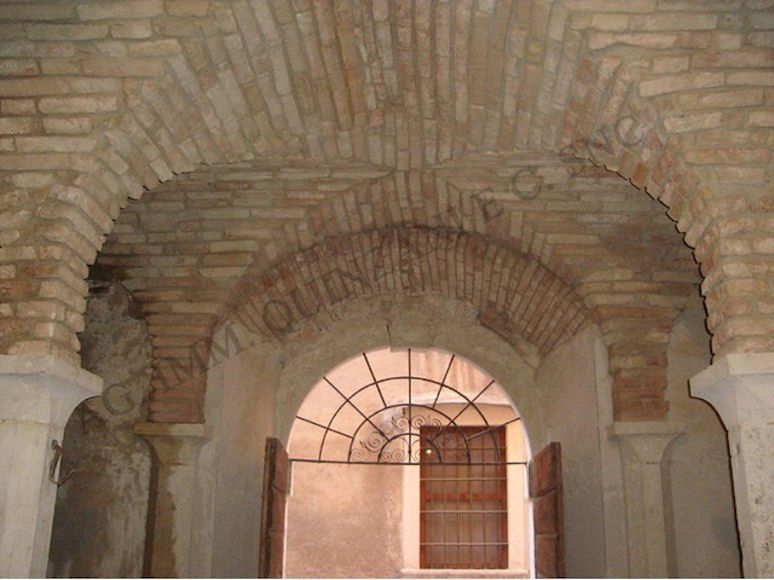 Un arco in mattoni in un edificio con una finestra