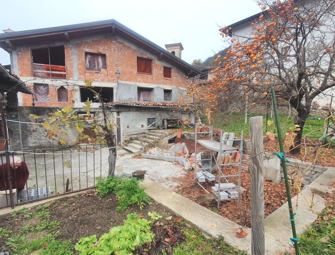 Una casa in costruzione con un giardino antistante.