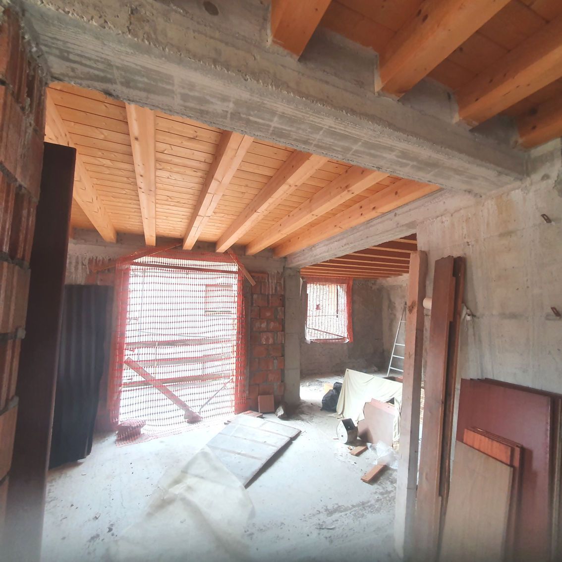 Una stanza con soffitto in legno e pareti in mattoni