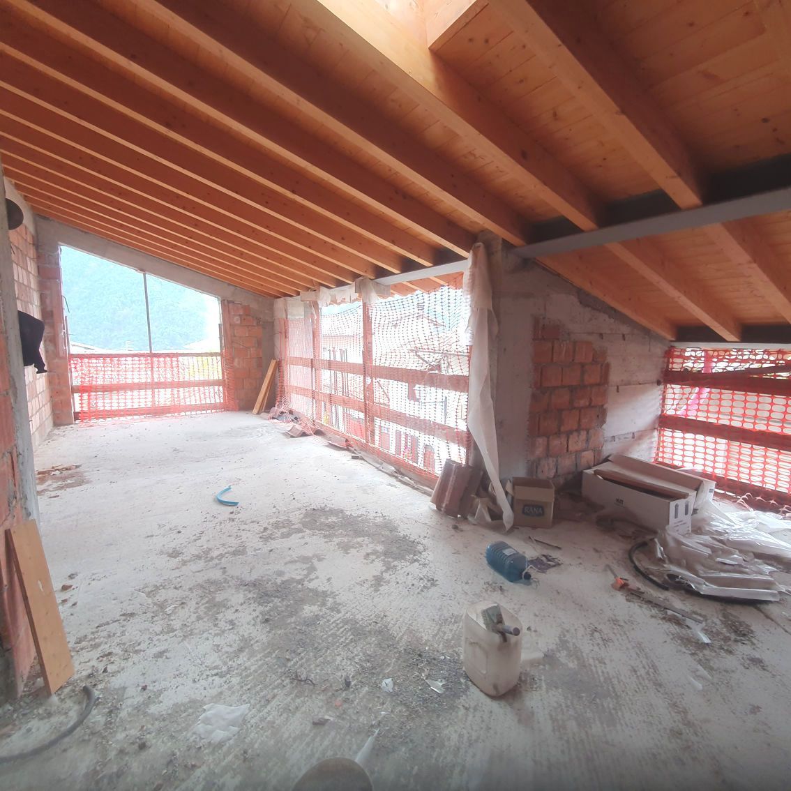 Una stanza vuota con soffitto in legno e pareti in mattoni