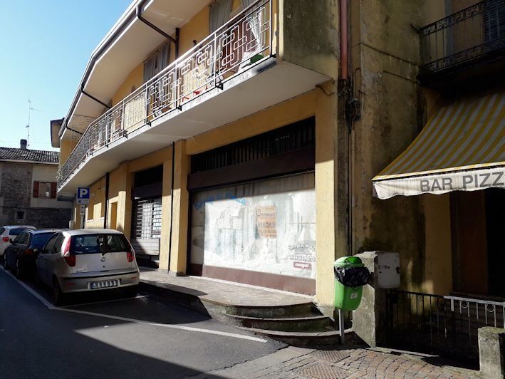 Un'auto è parcheggiata davanti a un edificio con la scritta bar pizza