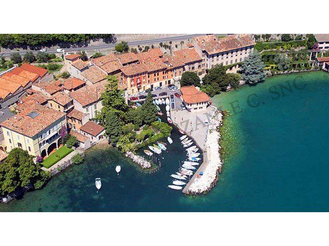 Una veduta aerea di una piccola città sulla riva di un lago con barche attraccate.