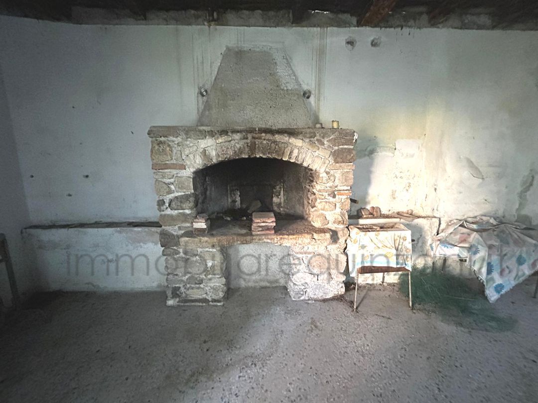 C'è un camino in pietra al centro di una stanza.