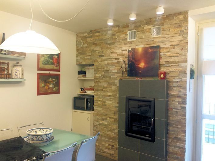 Una cucina con tavolo, sedie e camino.