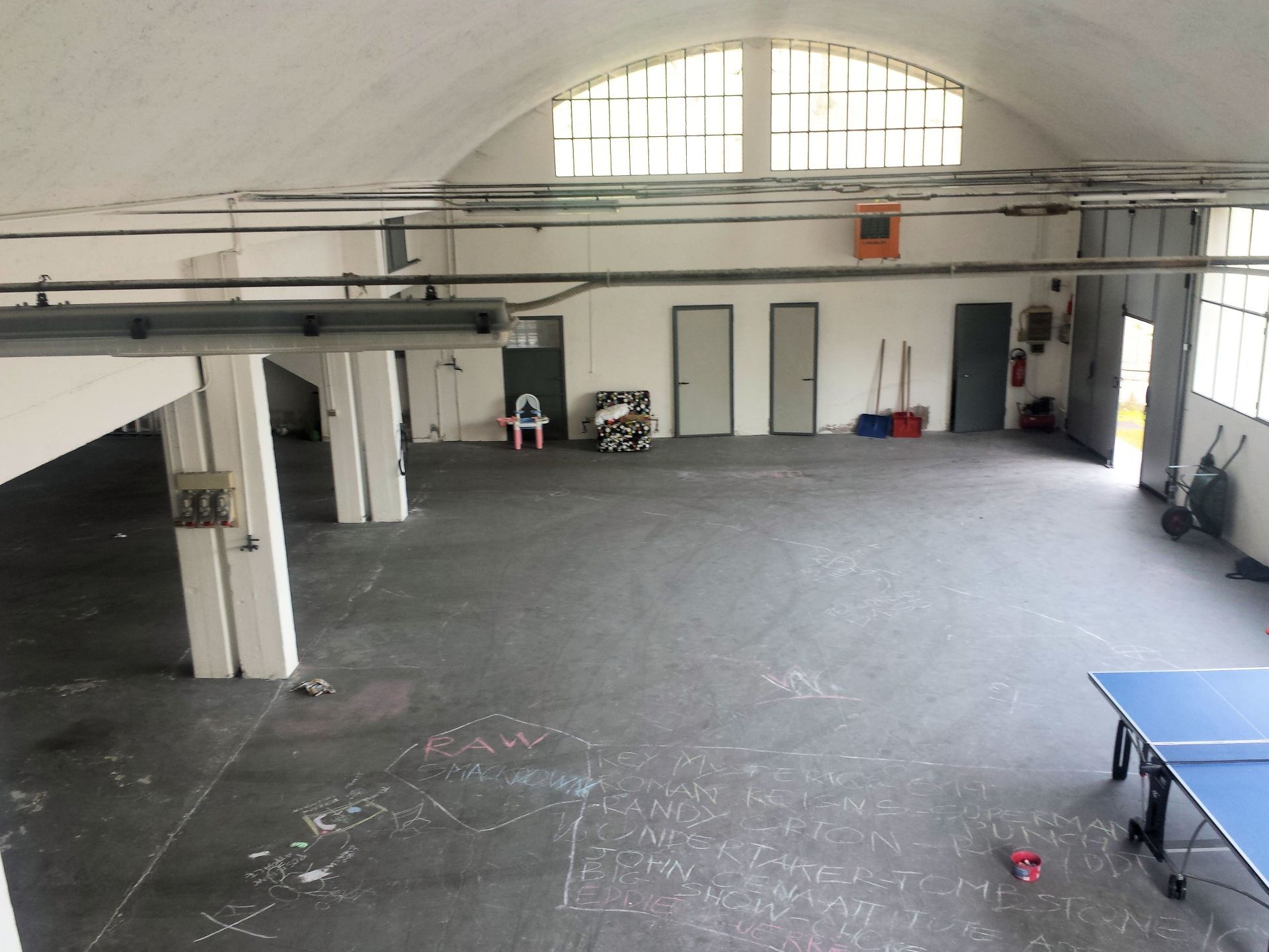 Un magazzino vuoto con un tavolo da ping pong al centro