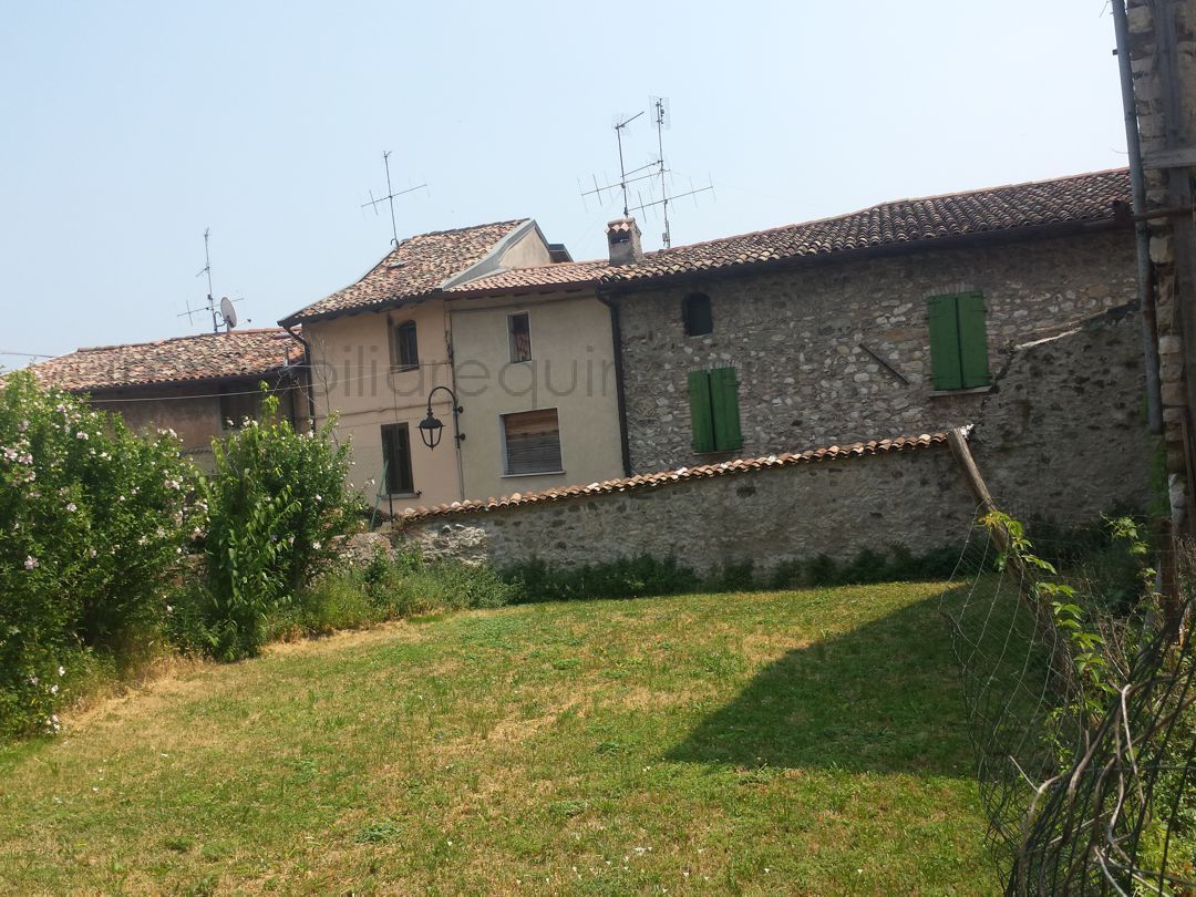 Un edificio in pietra con persiane verdi alle finestre