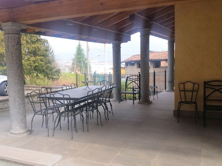 Un patio con tavolo e sedie sotto una tettoia