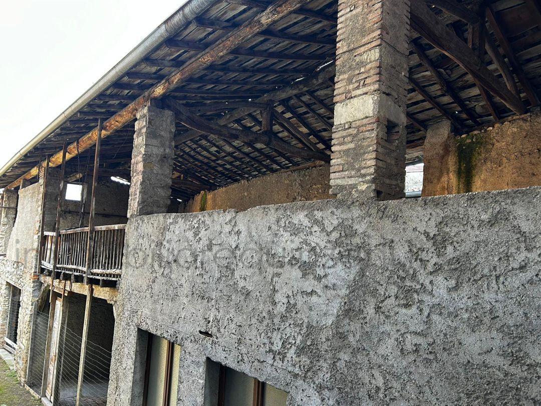 Un grande edificio in pietra con tetto in legno e balcone.