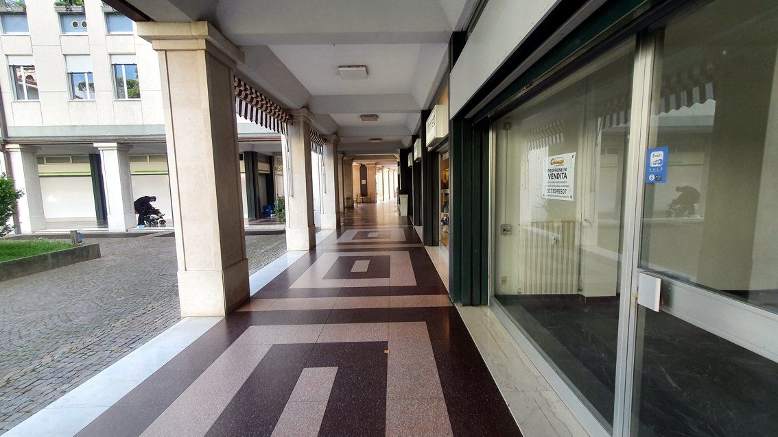 Un lungo corridoio tra due edifici con un motivo geometrico sul pavimento.