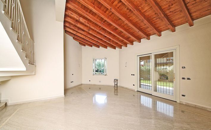 Una stanza vuota con un soffitto in legno e porte scorrevoli in vetro