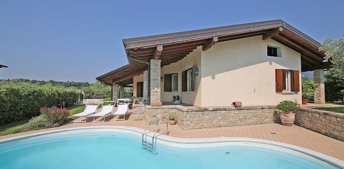 Una casa con una piscina di fronte.