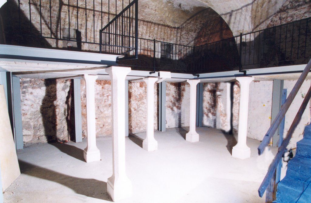 Una stanza con colonne e scale al suo interno