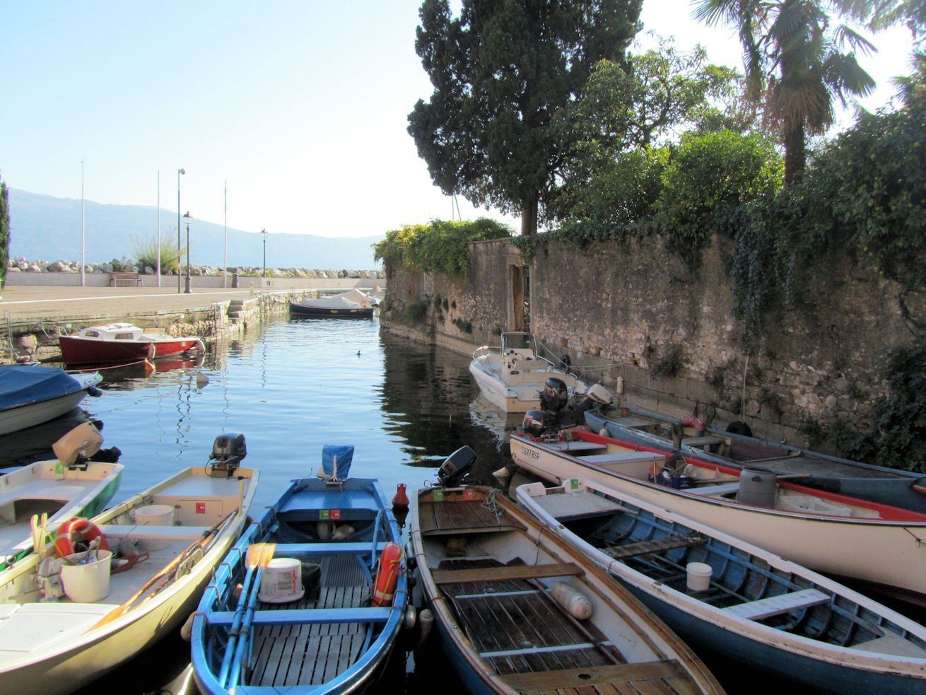 Una fila di piccole imbarcazioni sono attraccate in un porto