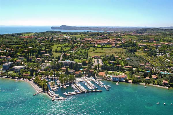 Una veduta aerea di una piccola città sulla riva di un grande specchio d'acqua.