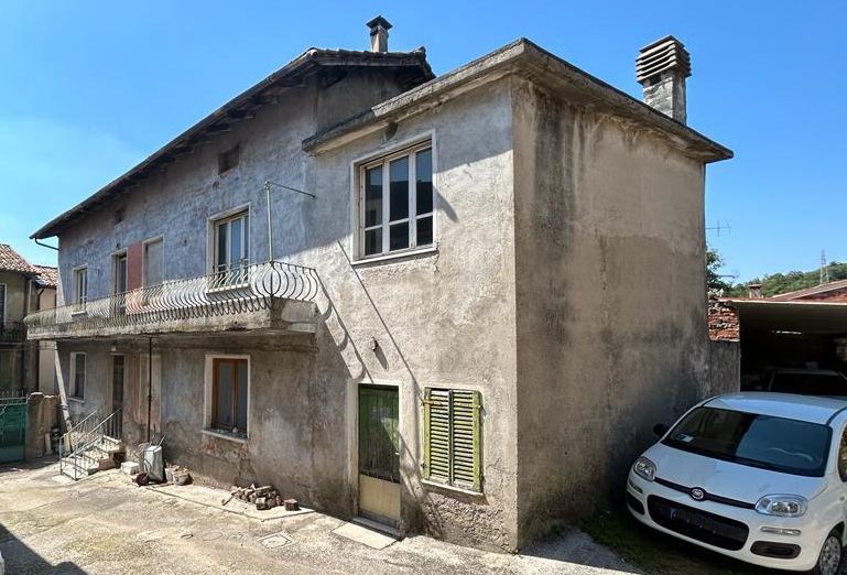 Un'auto bianca è parcheggiata davanti a un grande edificio.