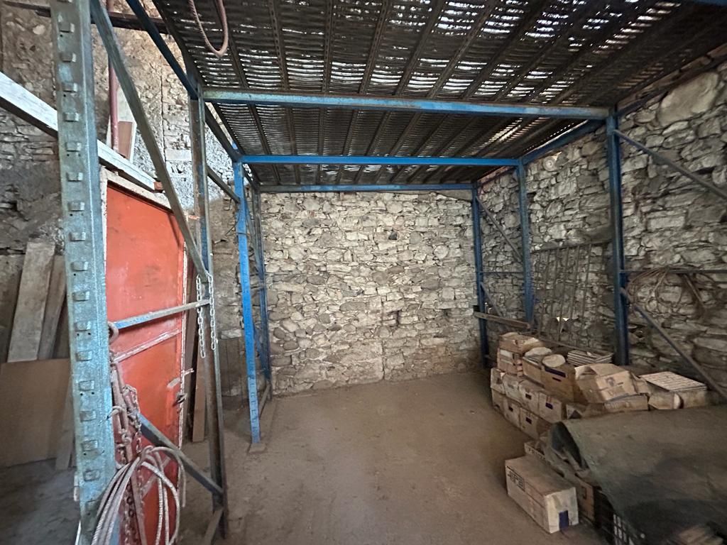 Una stanza vuota con un muro di mattoni e un tetto di metallo.