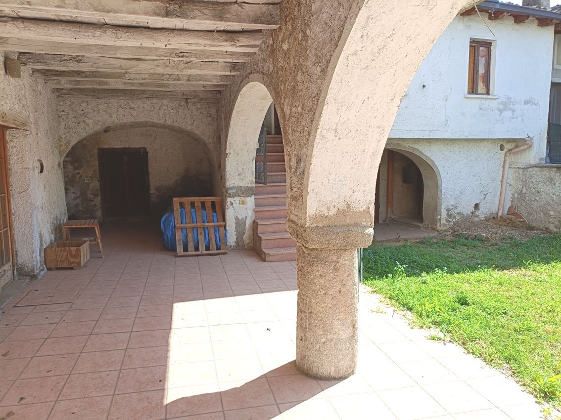 Un vecchio edificio con archi e scale nel cortile sul retro