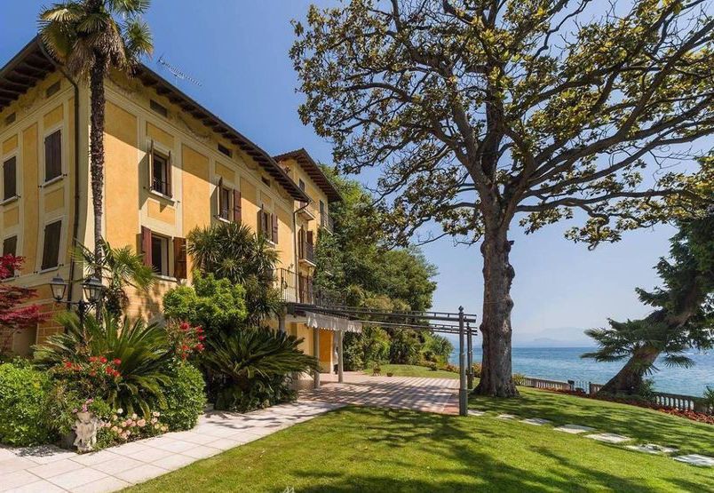 Una sala da pranzo con tavoli e sedie e un quadro sul muro.