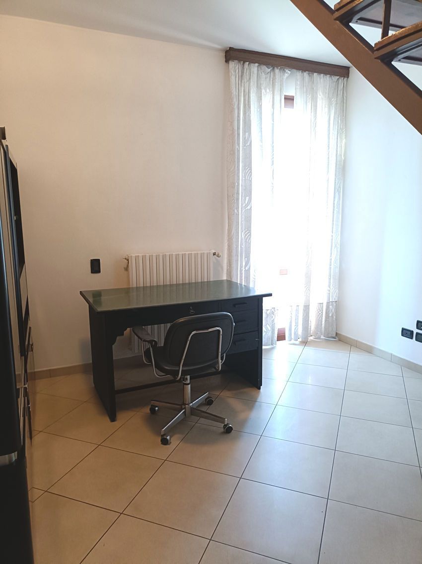 Una stanza con una scrivania e una sedia