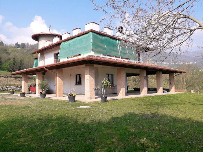 Una grande casa bianca con una tenda verde sul tetto