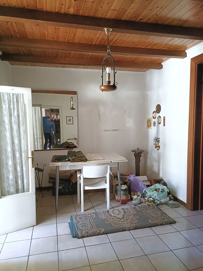 Una stanza con un tavolo, delle sedie e uno specchio