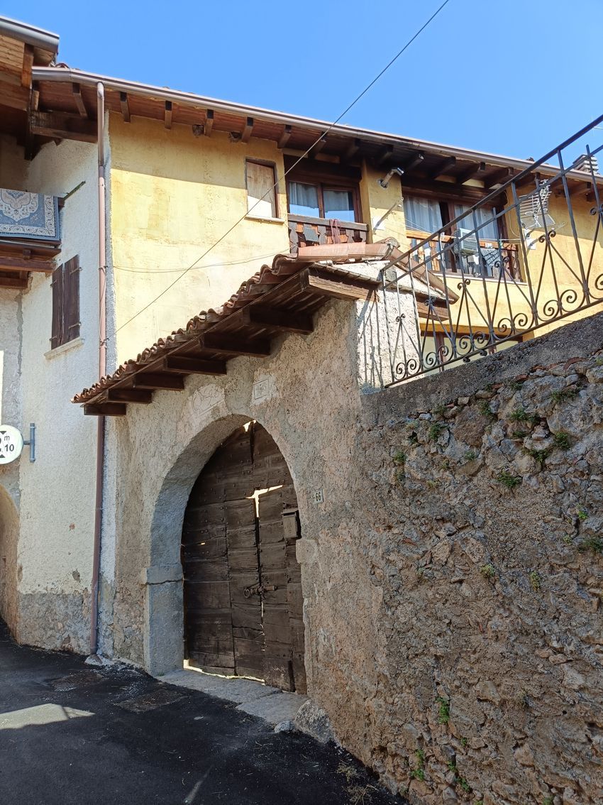 Un edificio giallo con un arco in pietra che vi conduce