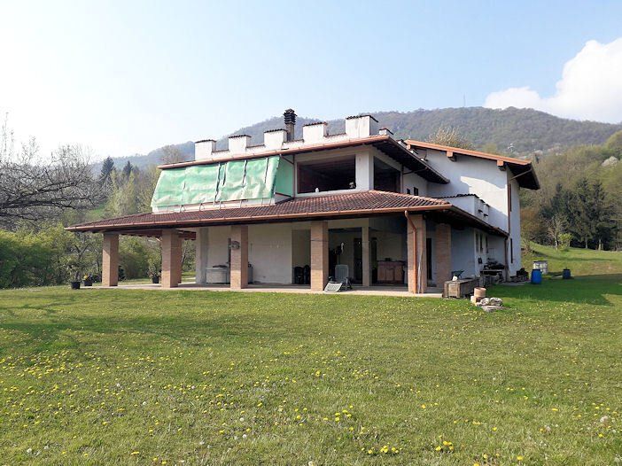 Una grande casa con un grande prato davanti