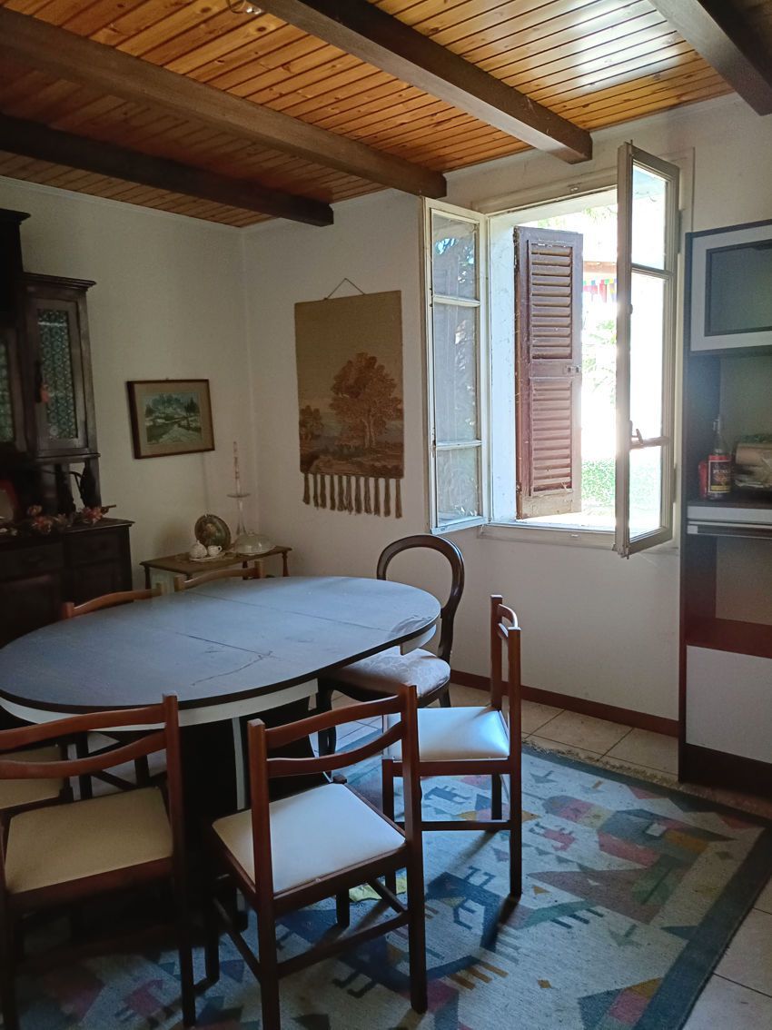 Una sala da pranzo con tavolo, sedie e una finestra.