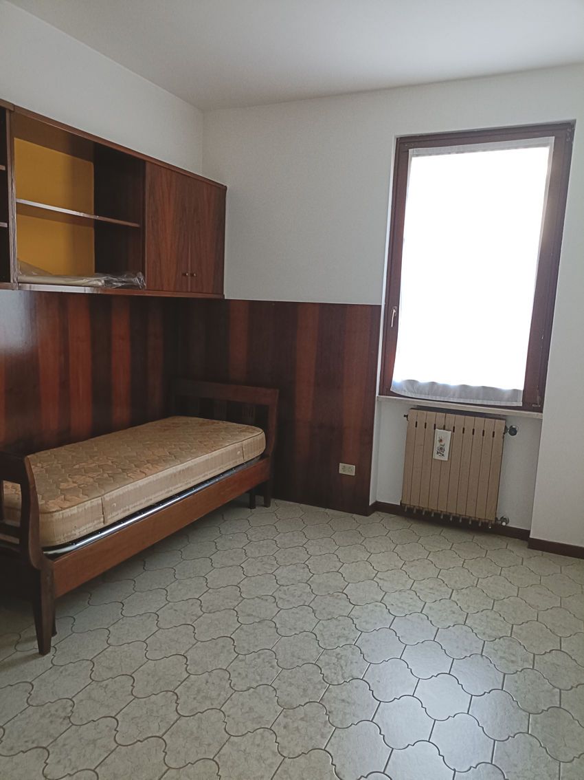 Una stanza vuota con un letto e una finestra