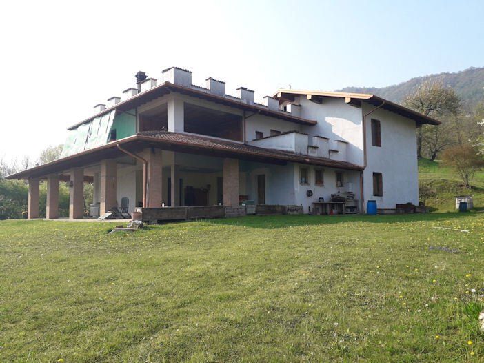 Una grande casa bianca con un grande prato davanti