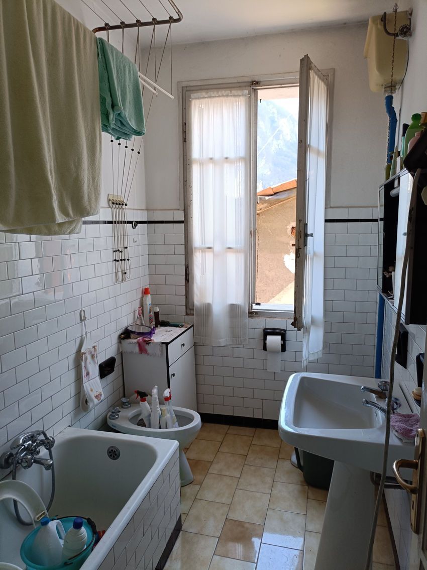 Un bagno con vasca, lavandino, wc e finestra.
