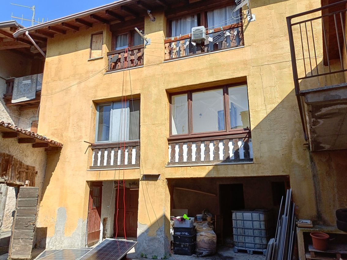 Un edificio giallo con un balcone e molte finestre.
