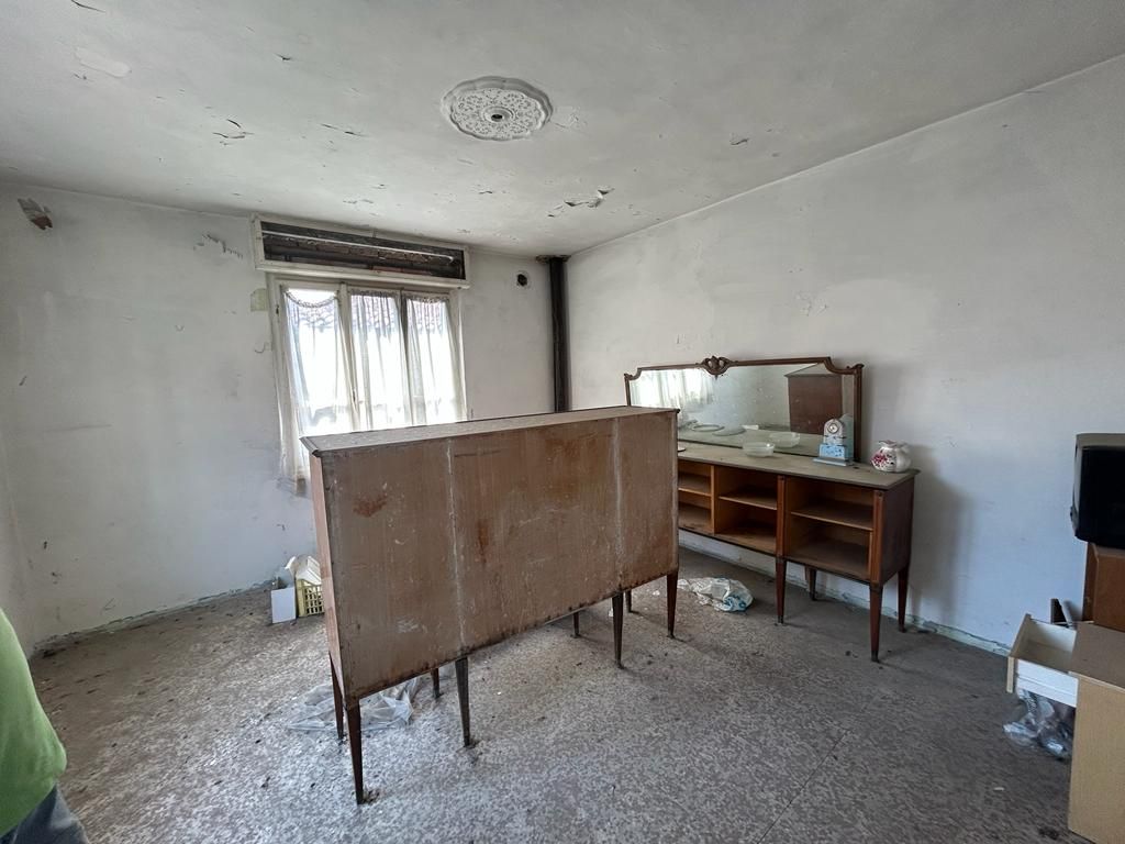 Una stanza con una cassettiera e uno specchio.