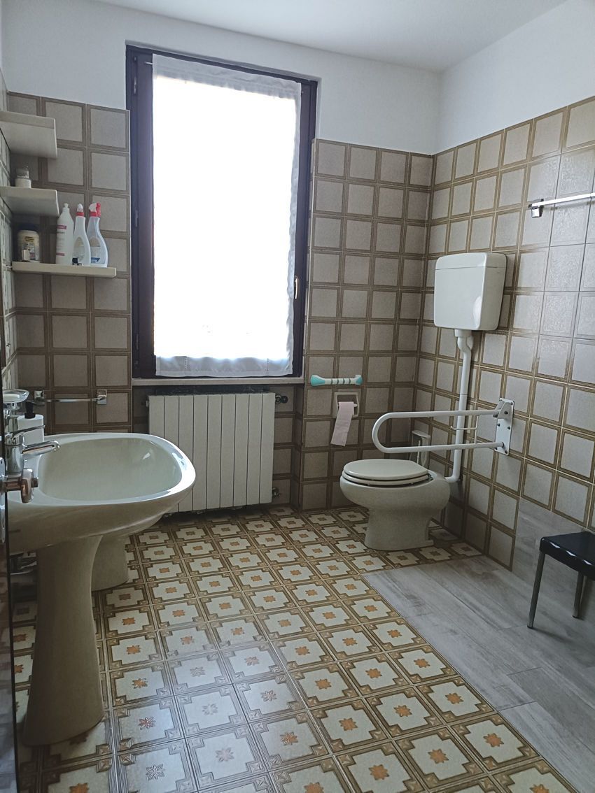 Un bagno con lavandino, water e finestra