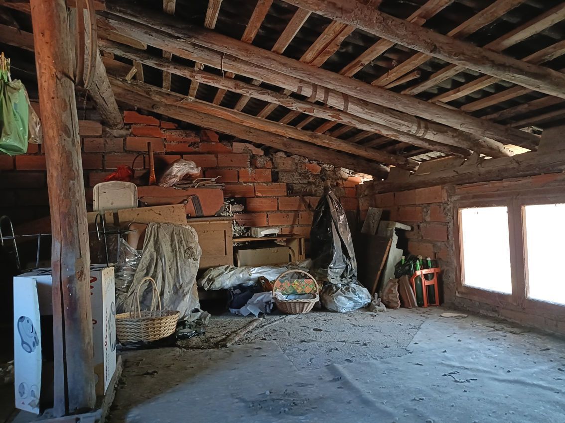 Una stanza con soffitto in legno e pareti in mattoni