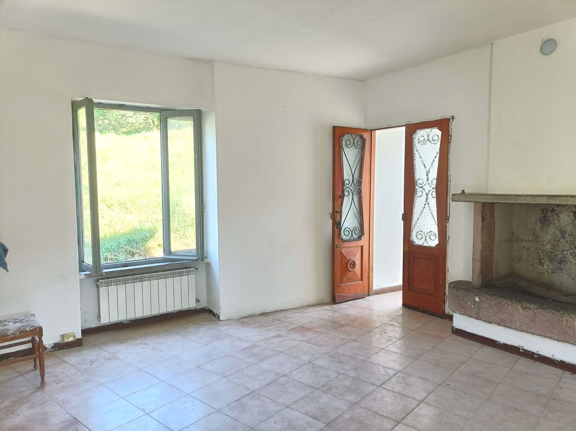 Un soggiorno vuoto con camino e finestra.