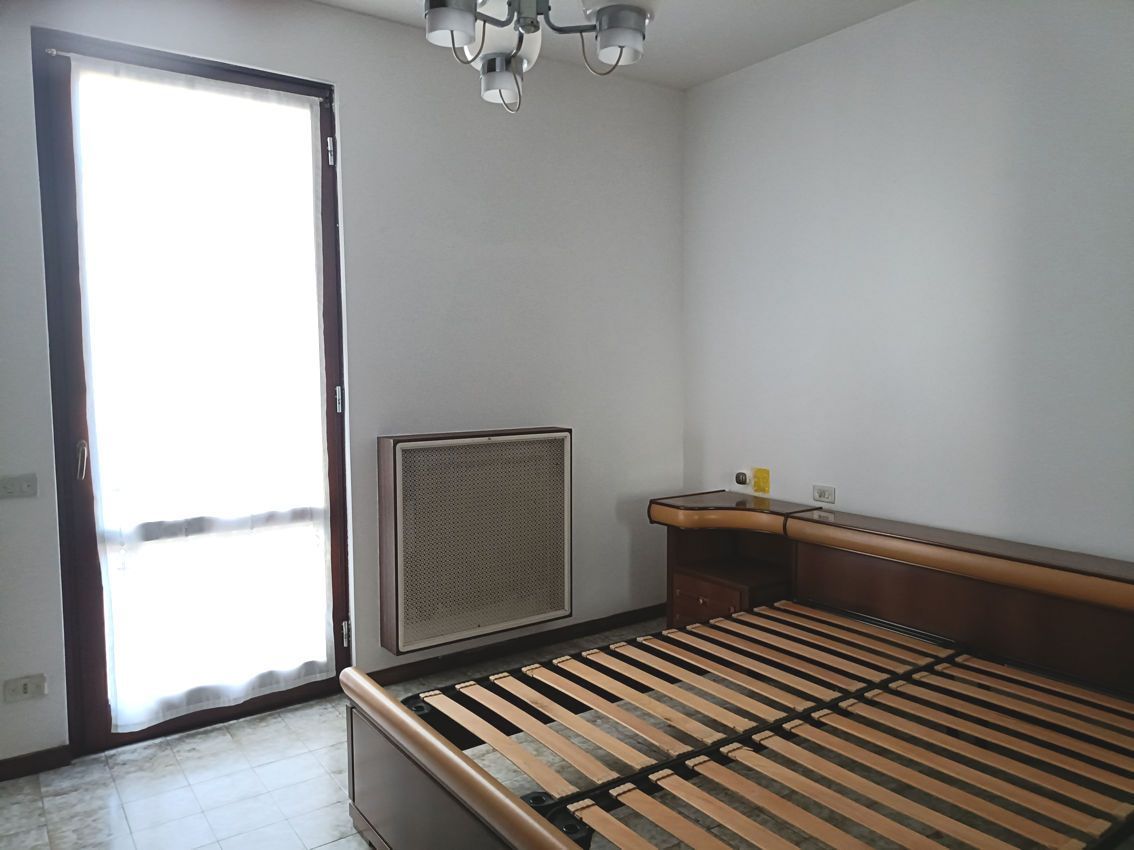 Una camera da letto vuota con un letto e una finestra