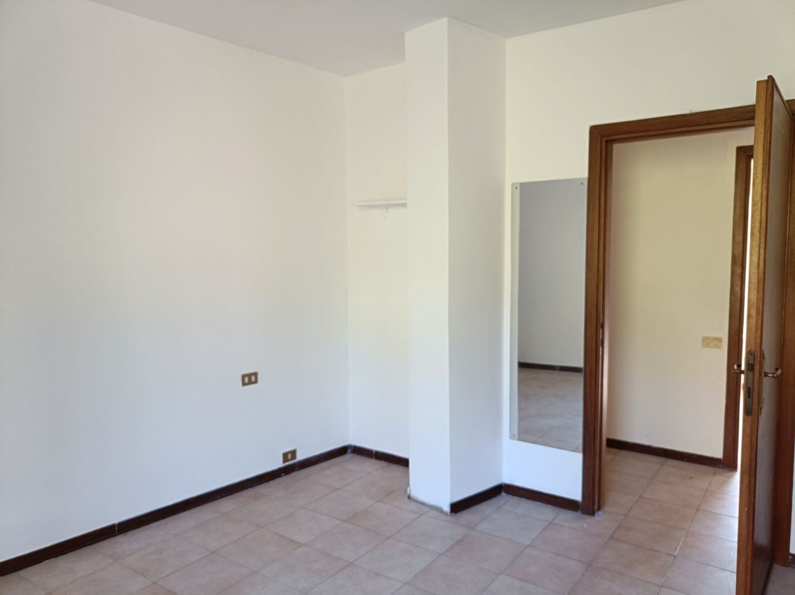 Una stanza vuota con uno specchio sul muro