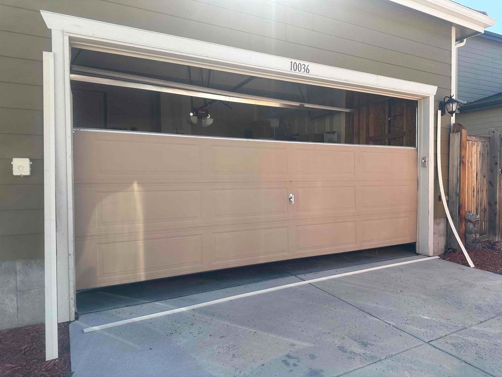 A garage door is open in front of a house.