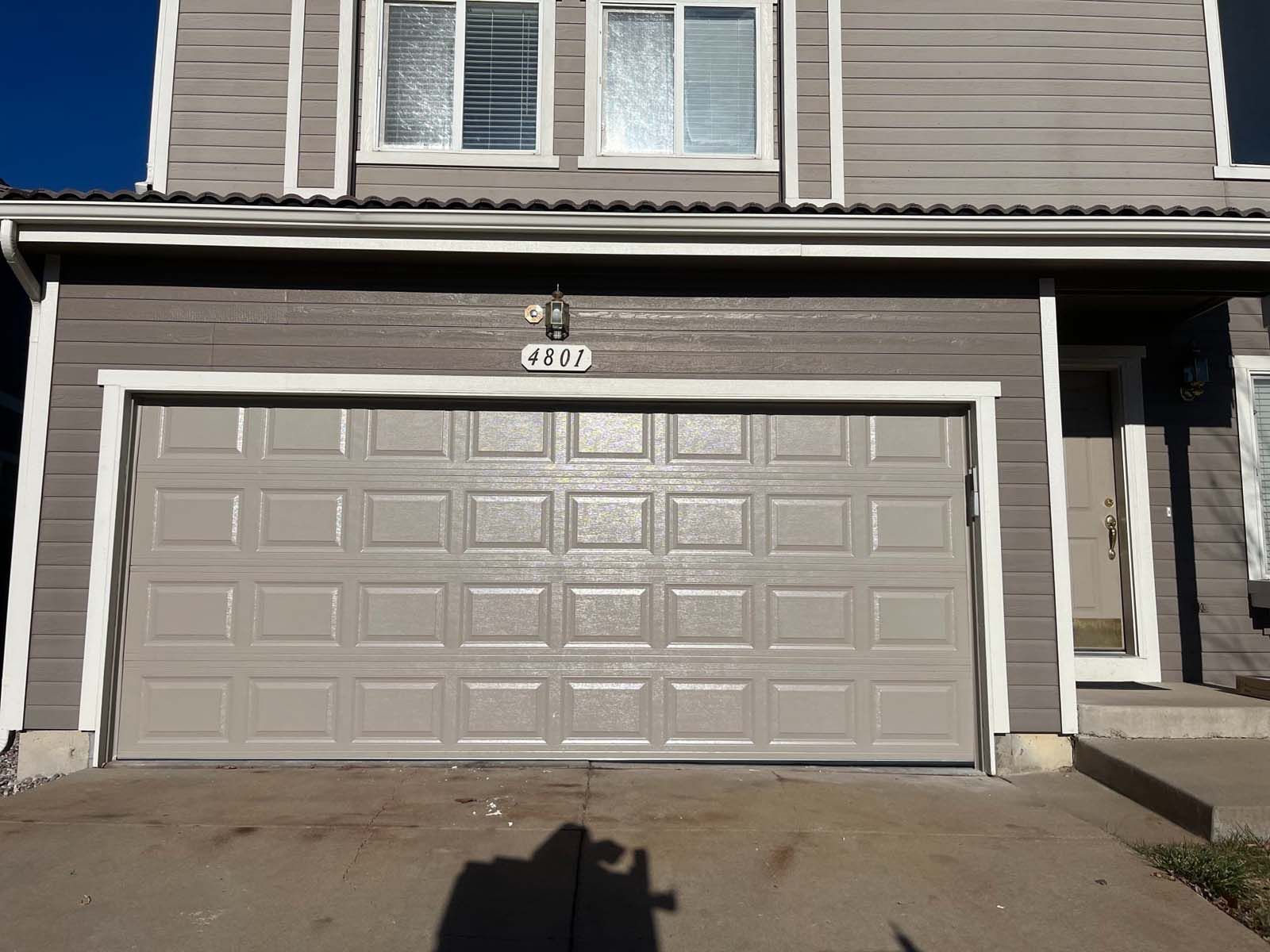 A house with a gray garage door and a white trim